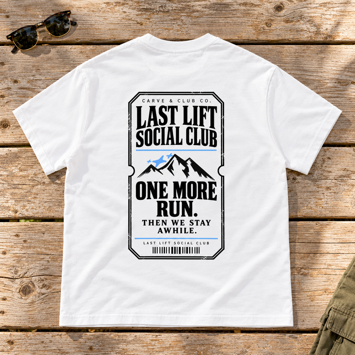 Last Lift Ticket Tee — back view flat lay on wood tabletop
