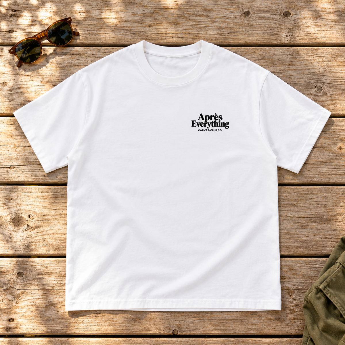 The Après Definition Tee — front view flat lay on wood tabletop