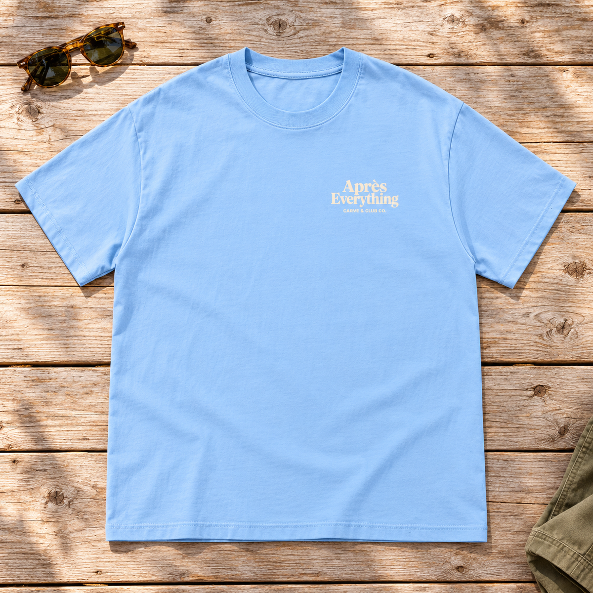 The Après Definition Tee — front view flat lay on wood tabletop
