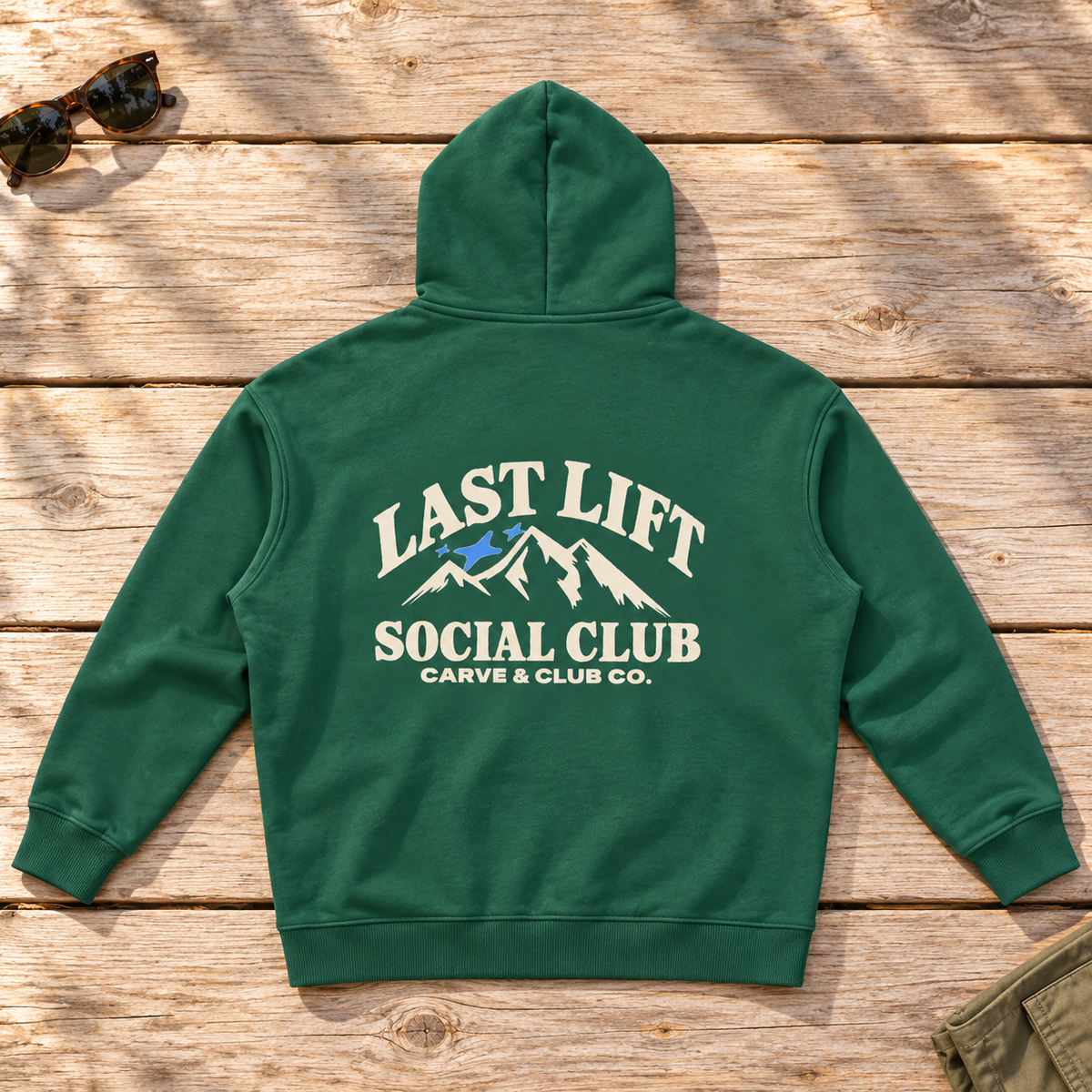 Last Lift Social Club Hoodie — back view flat lay on wood tabletop