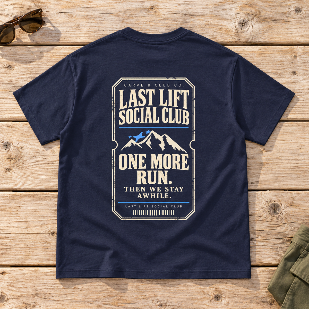 Last Lift Ticket Tee — back view flat lay on wood tabletop