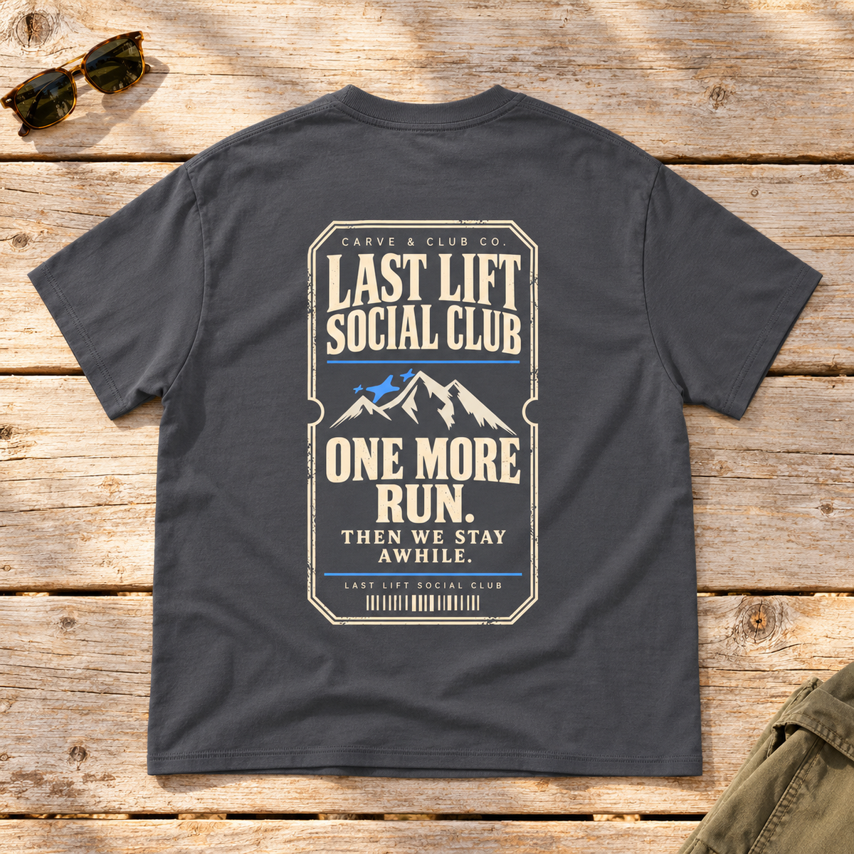 Last Lift Ticket Tee — back view flat lay on wood tabletop