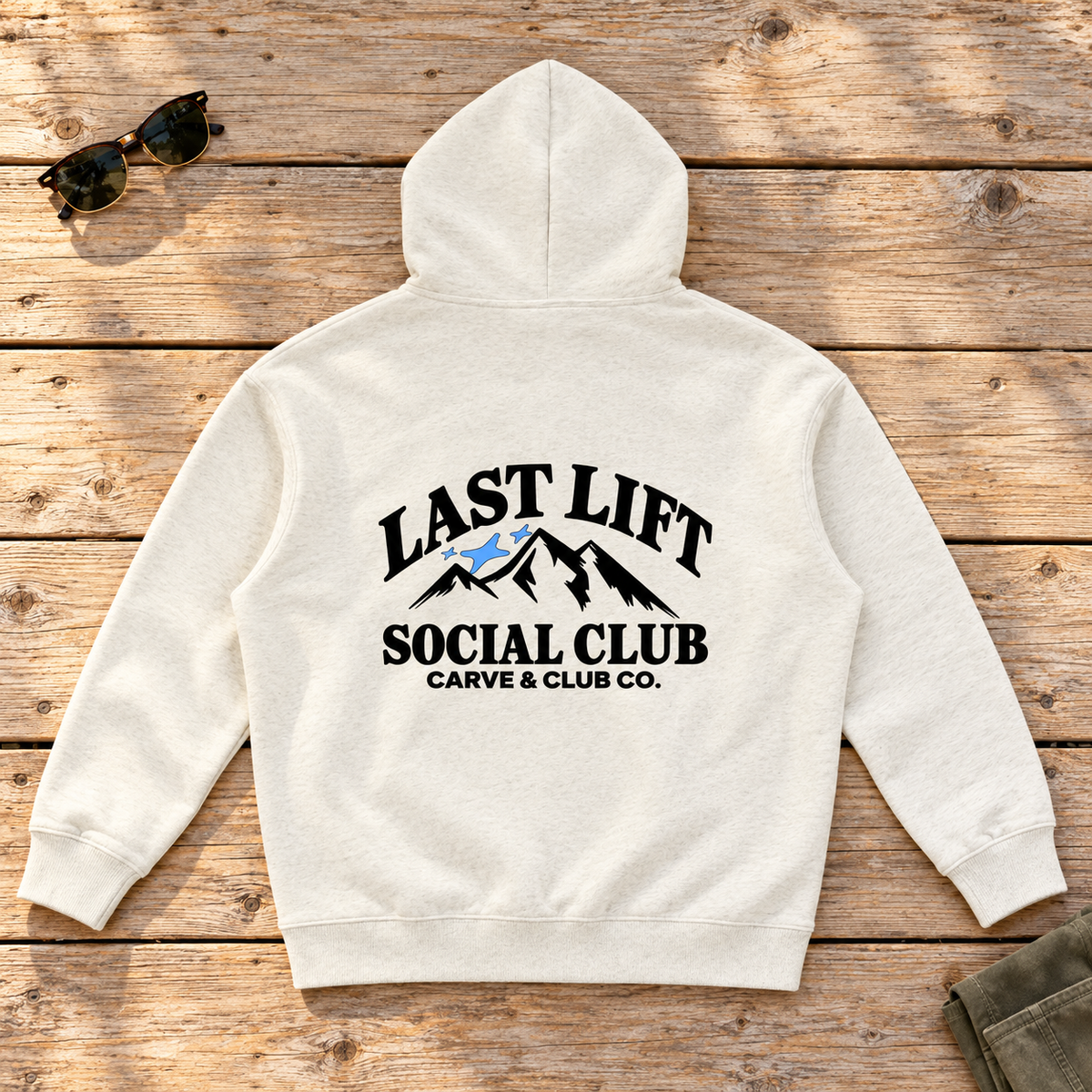 Last Lift Social Club Hoodie — back view flat lay on wood tabletop