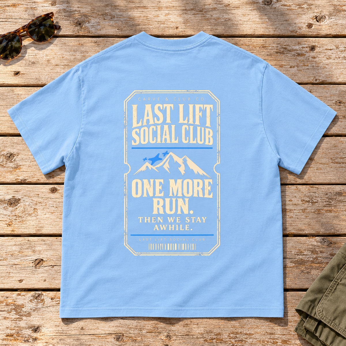 Last Lift Ticket Tee — back view flat lay on wood tabletop