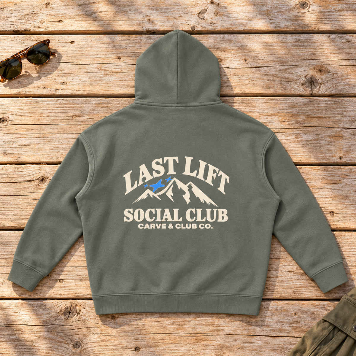 Last Lift Social Club Hoodie — back view flat lay on wood tabletop