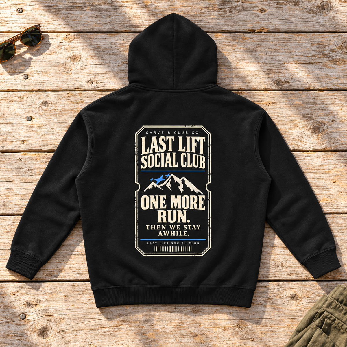 Last Lift Ticket Hoodie — back view flat lay on wood tabletop