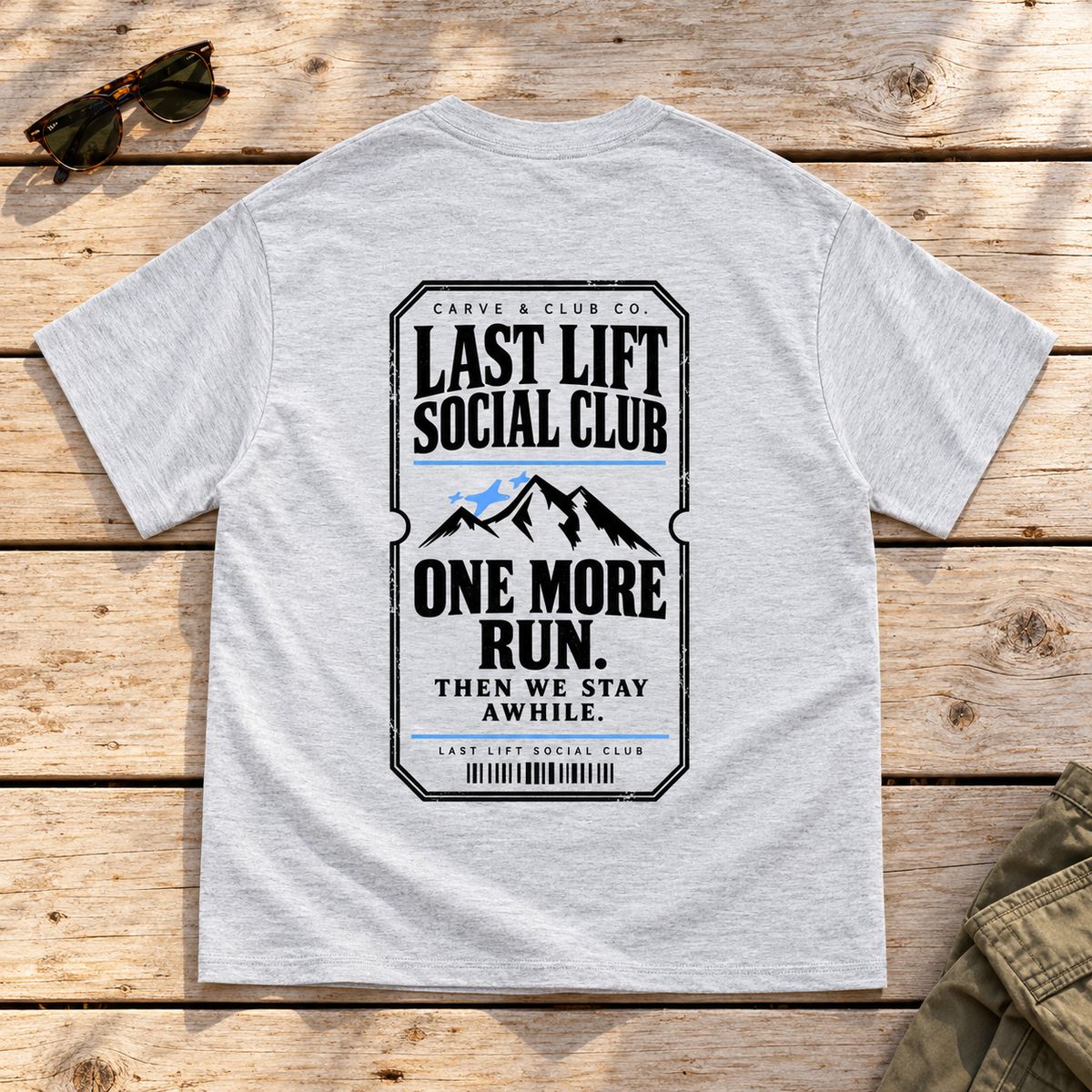 Last Lift Ticket Tee — back view flat lay on wood tabletop