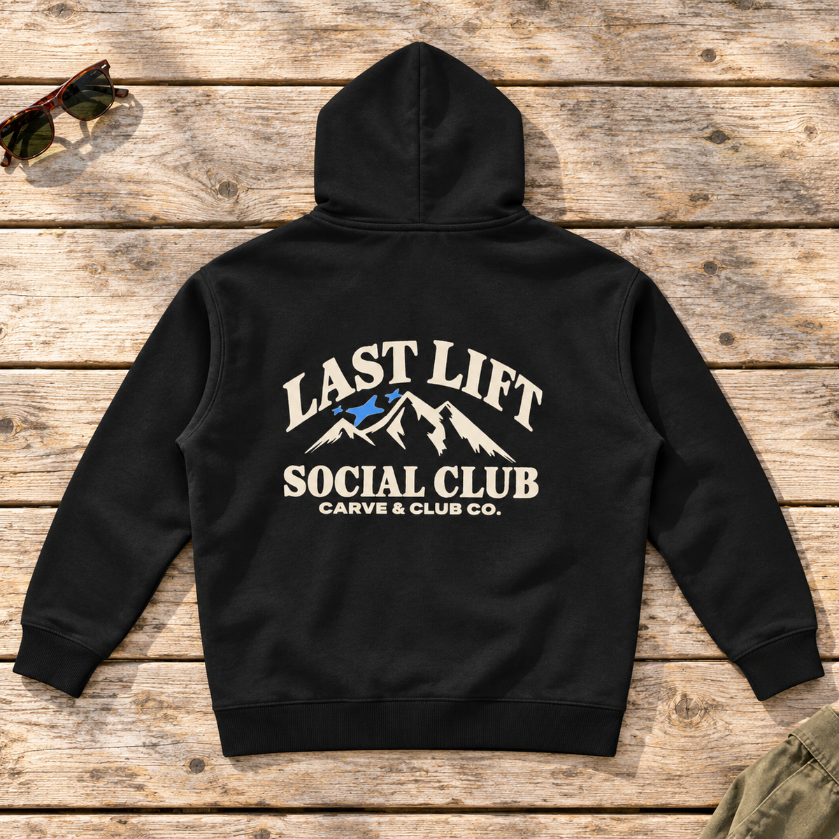 Last Lift Social Club Hoodie — back view flat lay on wood tabletop