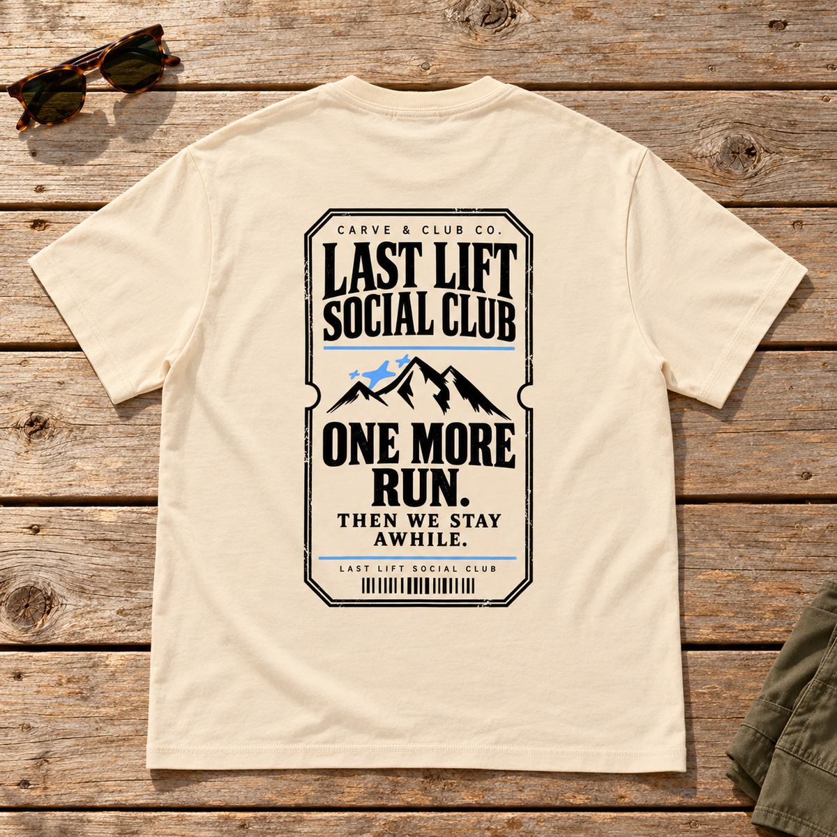 Last Lift Ticket Tee — back view flat lay on wood tabletop